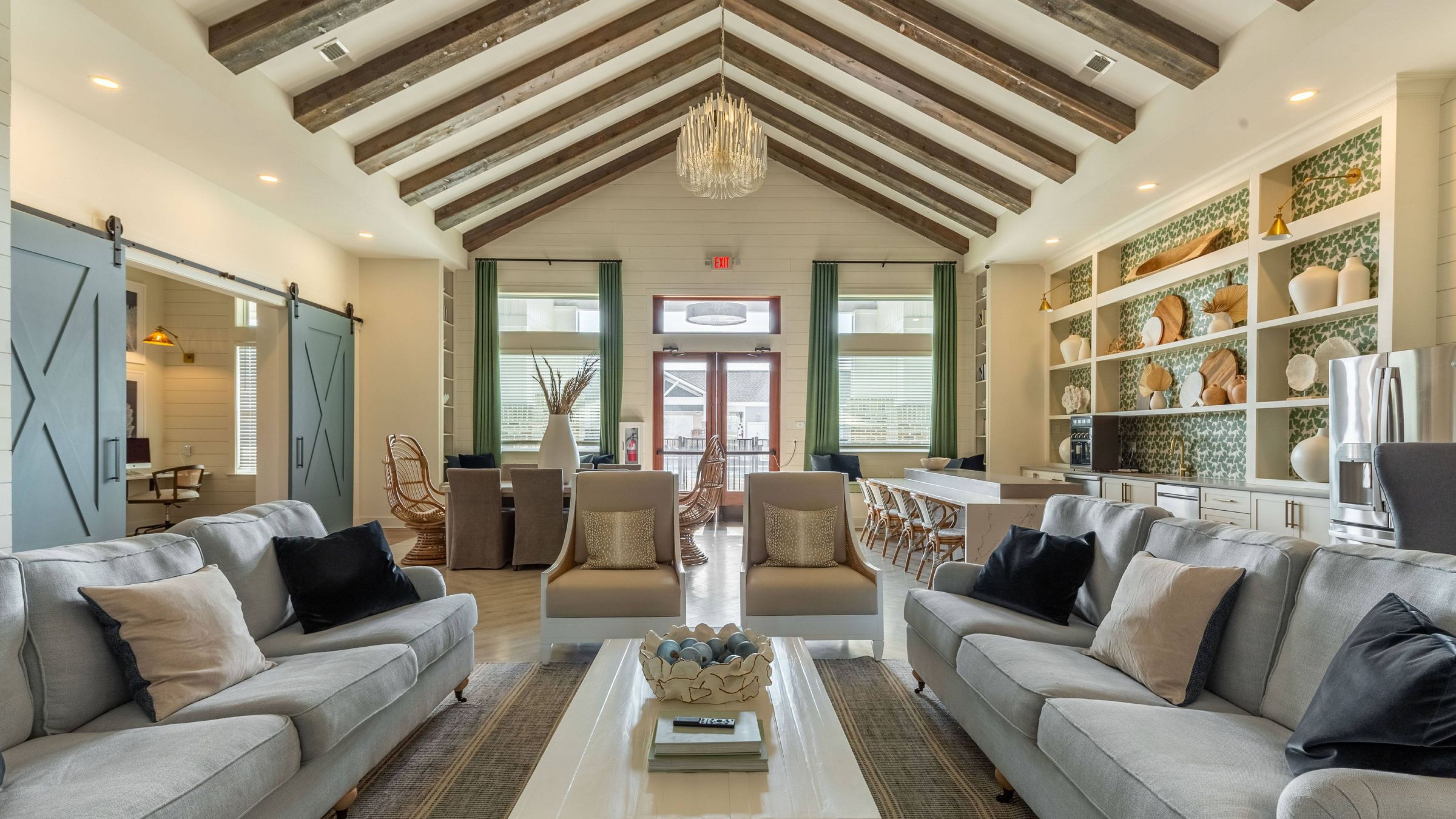 Hawthorne Waterside spacious clubhouse room with high ceilings featuring exposed beams, elegant seating, and stylish decor.
